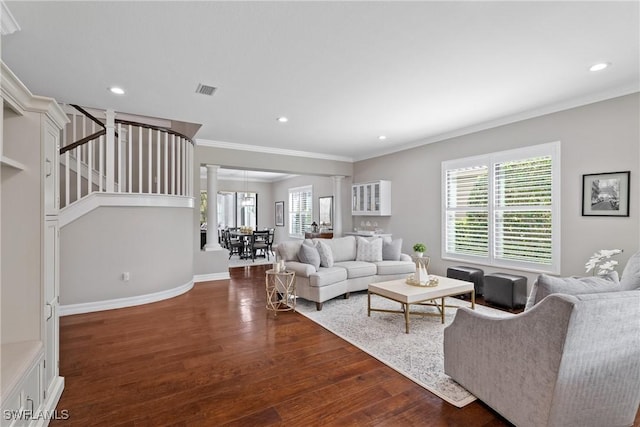 living area with a wealth of natural light, decorative columns, ornamental molding, and wood finished floors