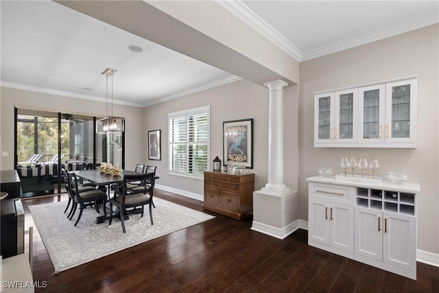 dining room featuring plenty of natural light, dark wood finished floors, decorative columns, and baseboards