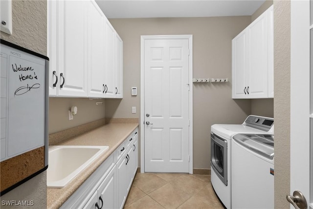 clothes washing area featuring light tile patterned flooring, independent washer and dryer, a sink, and cabinet space