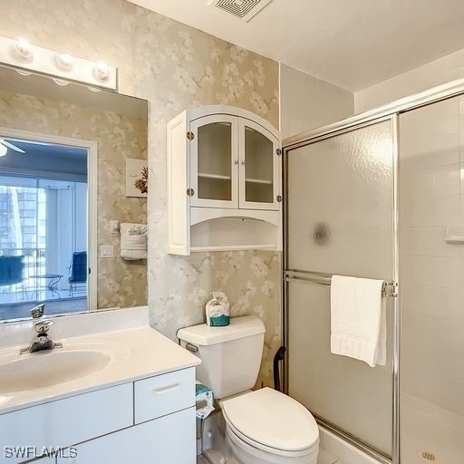 bathroom with visible vents, a stall shower, toilet, and wallpapered walls