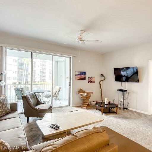 living area with ceiling fan, carpet flooring, and baseboards