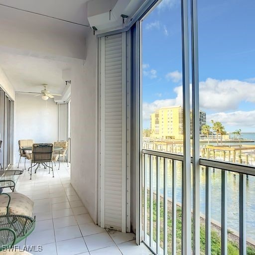 interior space with a ceiling fan and a water view