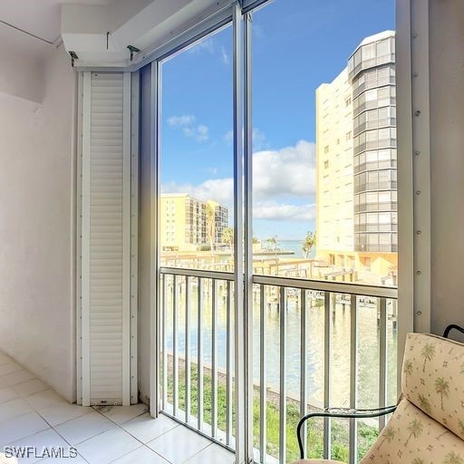 balcony featuring a water view and a city view