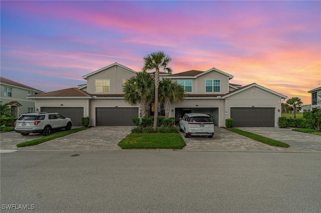 view of property featuring decorative driveway and a garage