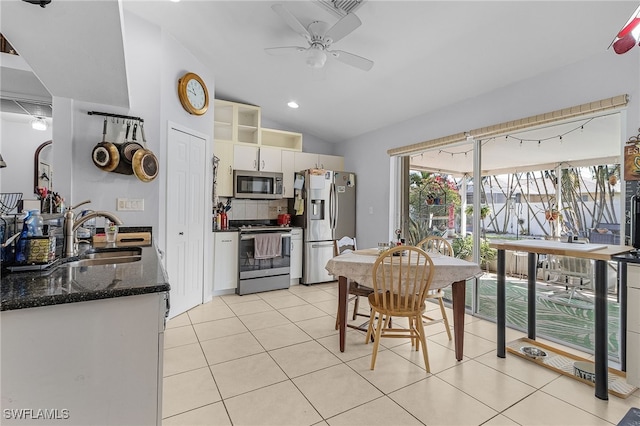 kitchen featuring light tile patterned floors, lofted ceiling, ceiling fan, appliances with stainless steel finishes, and a sink