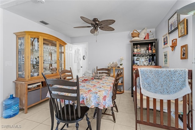 dining space featuring a ceiling fan, visible vents, a dry bar, and light tile patterned floors