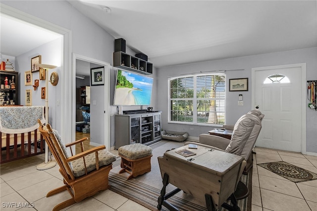 living area featuring lofted ceiling, baseboards, and light tile patterned floors