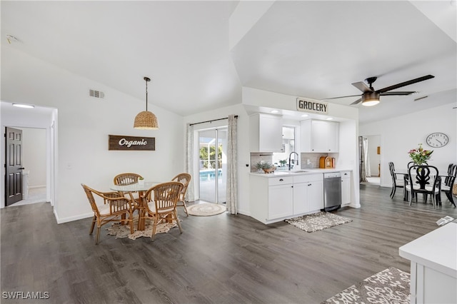 kitchen with lofted ceiling, white cabinets, light countertops, and a sink