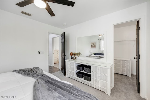 carpeted bedroom with ceiling fan and visible vents