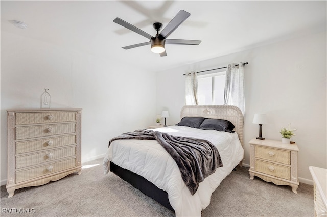 bedroom with light colored carpet, ceiling fan, and baseboards