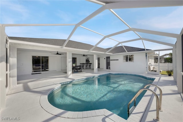 view of swimming pool with a fenced in pool, glass enclosure, a patio area, and ceiling fan