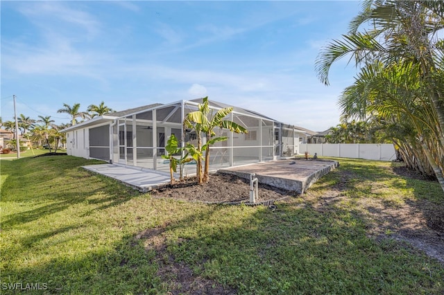 back of property with a lanai, a patio area, fence, and a yard