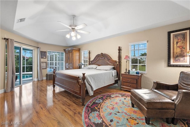 bedroom featuring access to outside, multiple windows, wood finished floors, and visible vents