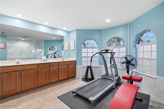 exercise room featuring light tile patterned floors, a sink, and recessed lighting