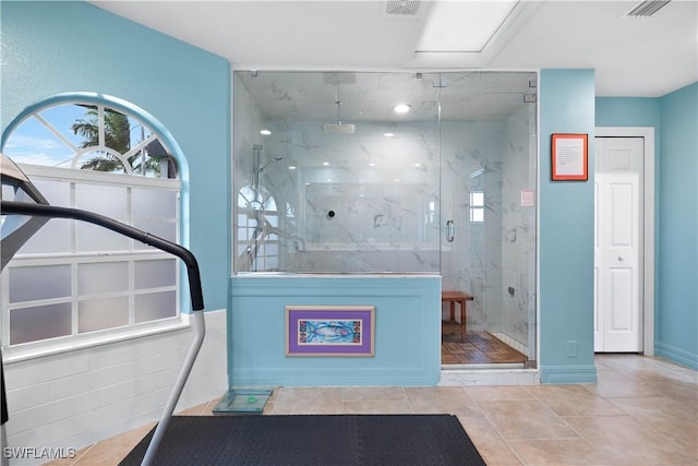 bathroom with tile patterned flooring, a marble finish shower, and visible vents