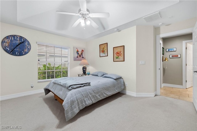 carpeted bedroom featuring ceiling fan, baseboards, visible vents, and a raised ceiling