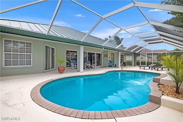 outdoor pool featuring a patio area, glass enclosure, and a ceiling fan