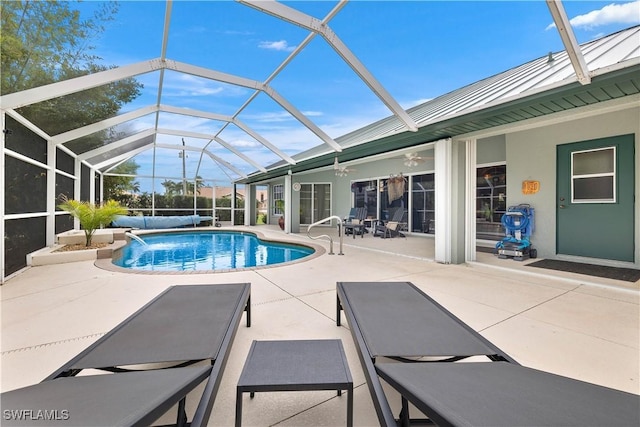 pool featuring ceiling fan, glass enclosure, and a patio area