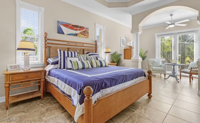 bedroom featuring decorative columns, arched walkways, a ceiling fan, tile patterned floors, and crown molding