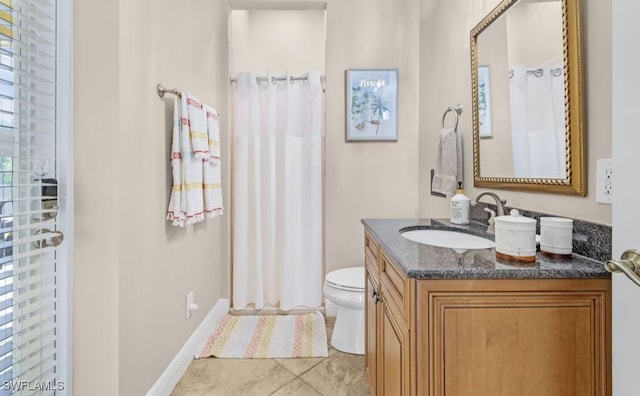 bathroom with curtained shower, baseboards, vanity, and toilet