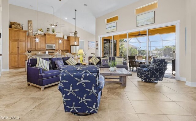 living room featuring ceiling fan, high vaulted ceiling, light tile patterned floors, a sunroom, and baseboards