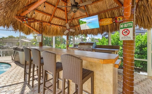 view of patio / terrace with a gazebo, outdoor wet bar, area for grilling, and a ceiling fan