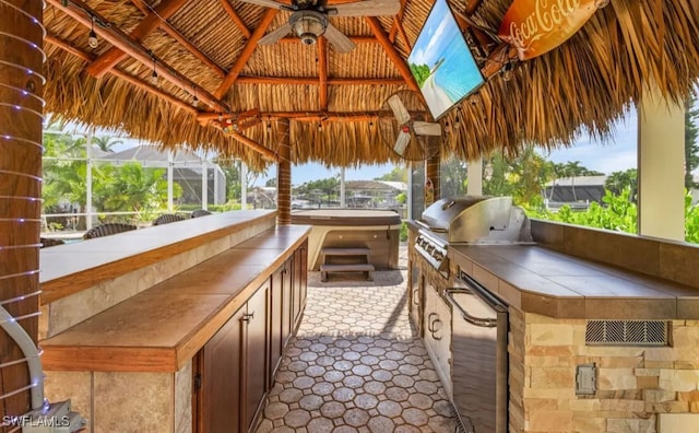 view of patio / terrace with ceiling fan, a lanai, area for grilling, a gazebo, and grilling area