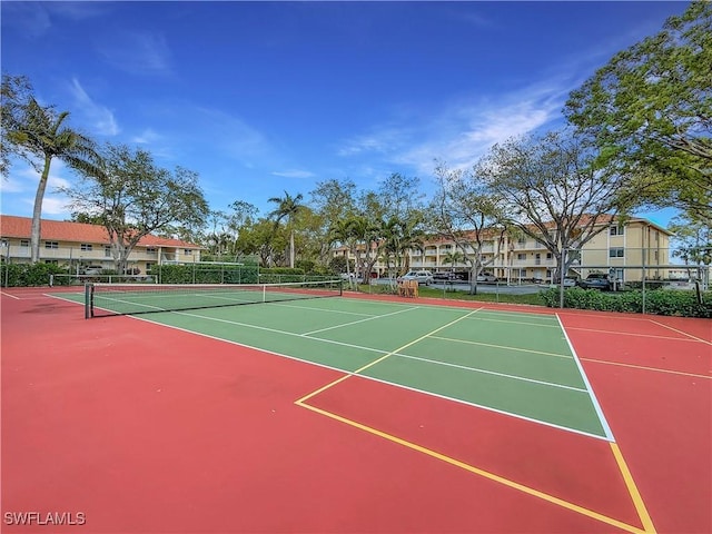 view of tennis court featuring community basketball court and fence