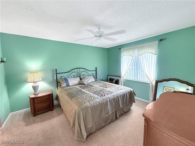 bedroom featuring a ceiling fan, carpet, a textured ceiling, and baseboards