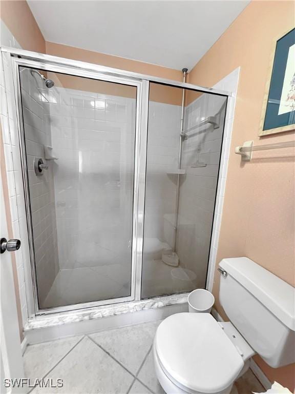 full bathroom with a stall shower, tile patterned flooring, and toilet