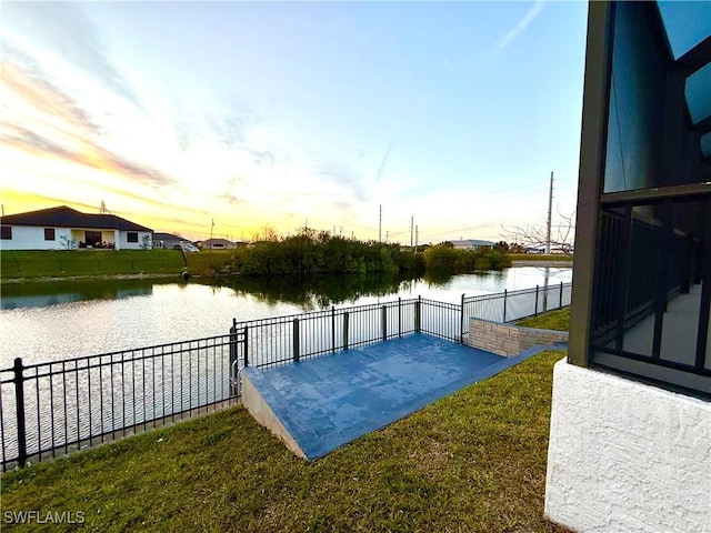 view of patio featuring a water view and fence