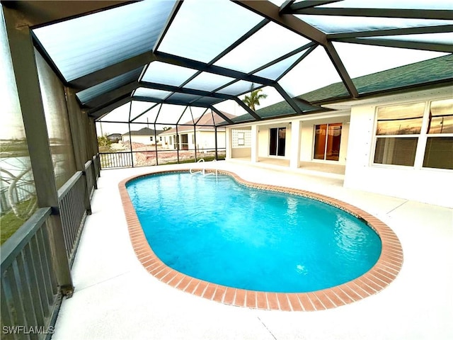 outdoor pool with a patio and glass enclosure