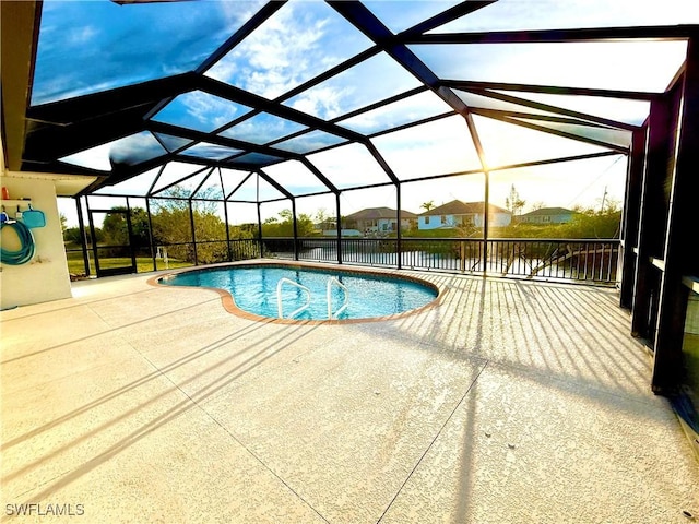 pool with a patio area and glass enclosure