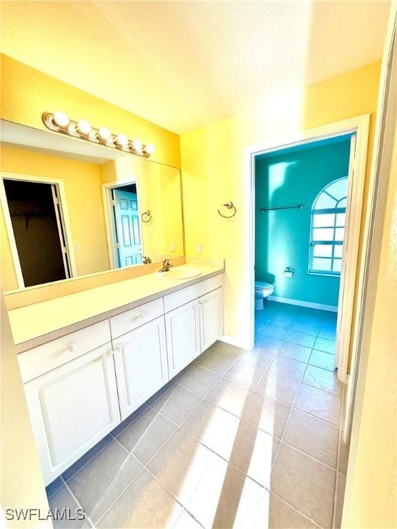 full bath with tile patterned flooring, baseboards, vanity, and toilet