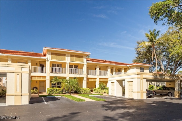 view of building exterior featuring covered and uncovered parking