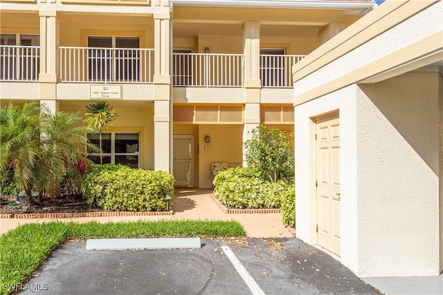 property entrance featuring uncovered parking and stucco siding