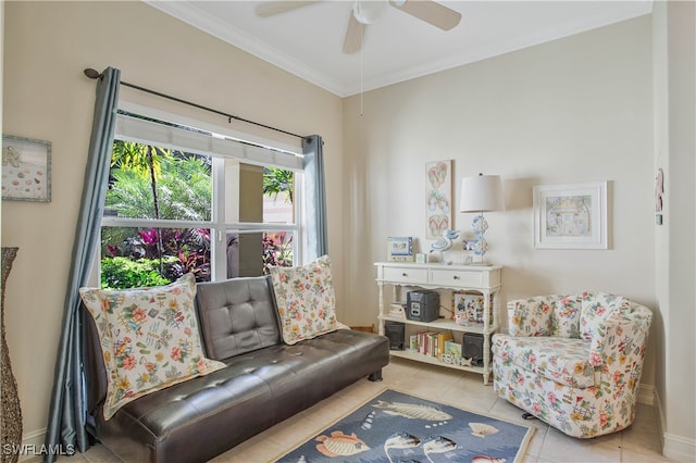 sitting room featuring ceiling fan, baseboards, tile patterned flooring, and crown molding