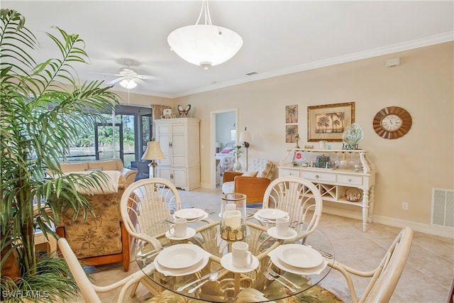 dining space featuring baseboards, a ceiling fan, visible vents, and crown molding