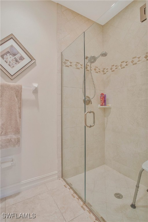 full bathroom featuring a stall shower and baseboards