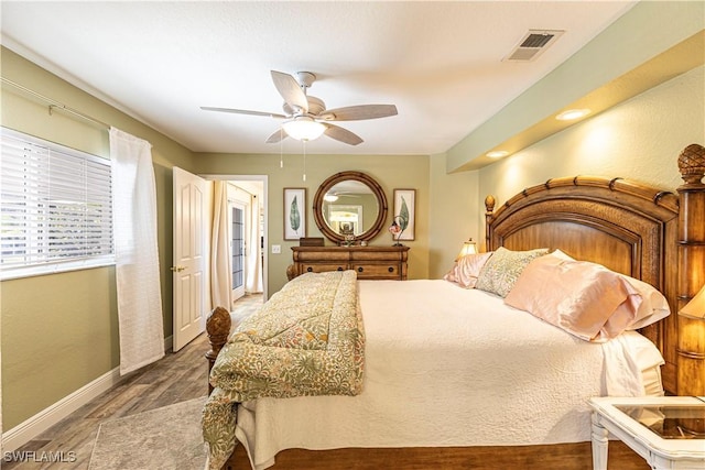 bedroom featuring ceiling fan, wood finished floors, visible vents, and baseboards