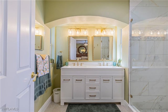 bathroom featuring double vanity, tile patterned flooring, a shower stall, and a sink