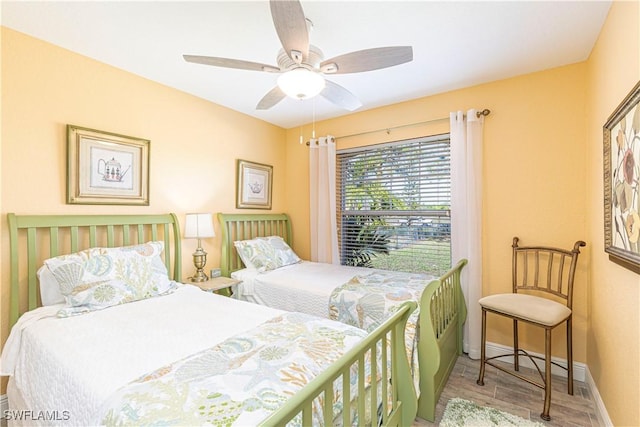 bedroom featuring a ceiling fan, wood finished floors, and baseboards