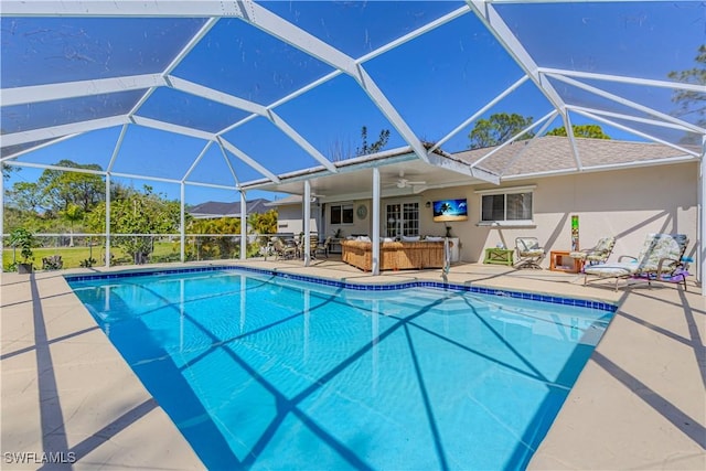 pool featuring glass enclosure, a patio, a ceiling fan, and an outdoor living space