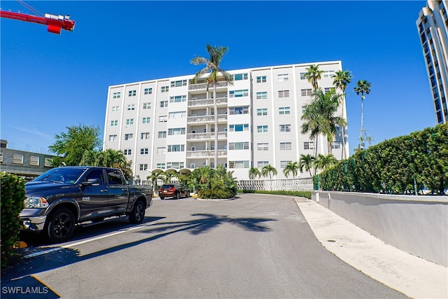 view of property featuring uncovered parking and fence