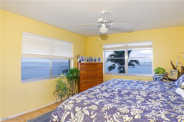 tiled bedroom featuring baseboards and ceiling fan