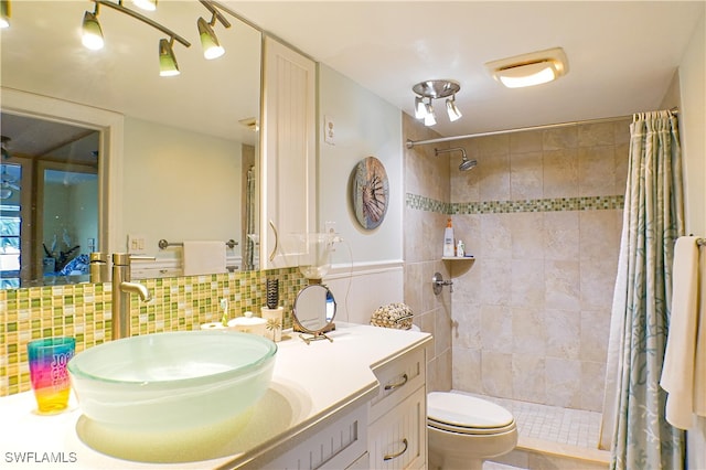 bathroom with decorative backsplash, tiled shower, toilet, and vanity