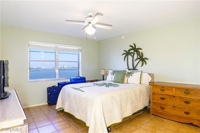 bedroom featuring light tile patterned flooring, a ceiling fan, and baseboards