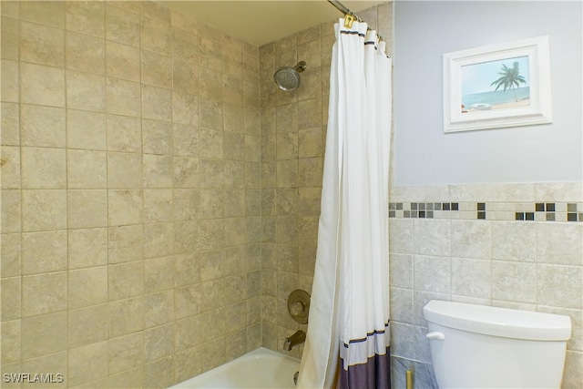 full bathroom with tile walls, shower / tub combo, and toilet