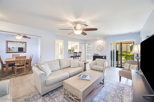 living area with light wood-style flooring and ceiling fan