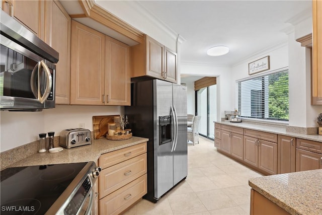 kitchen with light tile patterned floors, stainless steel appliances, light stone countertops, and ornamental molding